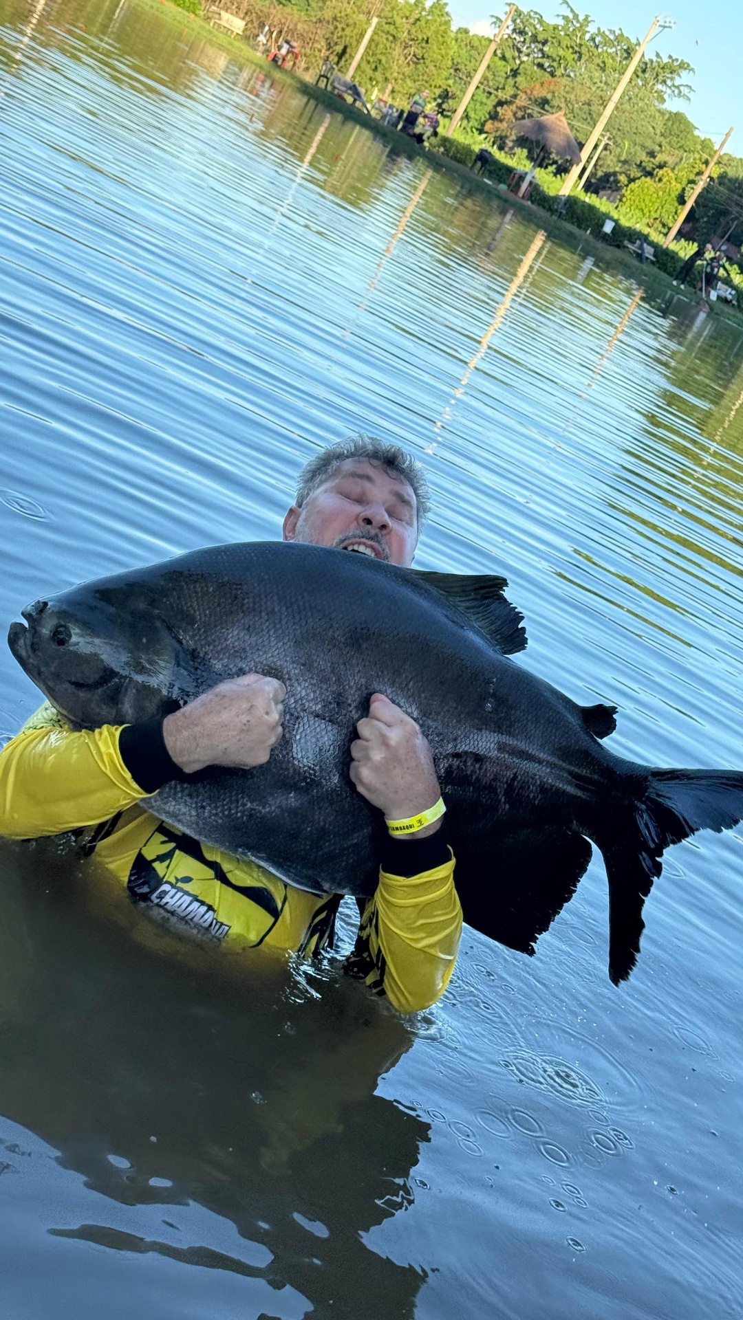 Pescador comemorando dentro do lago com tambaqui
